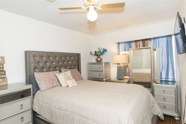 bedroom featuring dark hardwood / wood-style floors, a textured ceiling, and ceiling fan