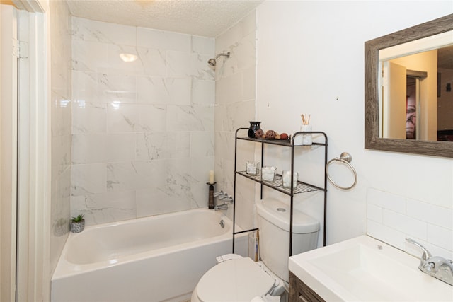 full bathroom with vanity, tiled shower / bath combo, a textured ceiling, and toilet