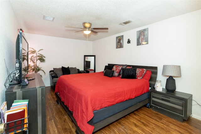 bedroom featuring ceiling fan, a textured ceiling, and dark hardwood / wood-style flooring