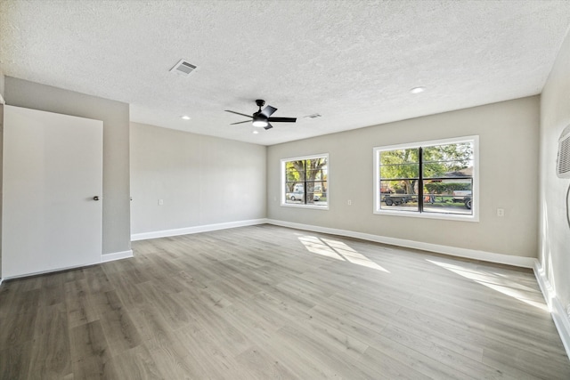 unfurnished room with light hardwood / wood-style floors, a textured ceiling, and ceiling fan