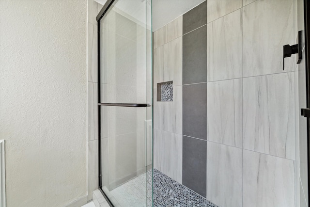 bathroom featuring a shower with shower door