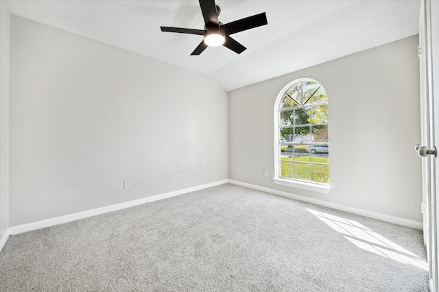 spare room featuring carpet floors, ceiling fan, and vaulted ceiling