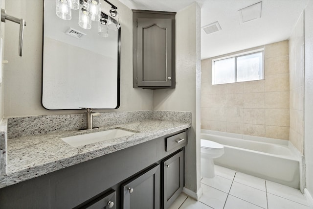 bathroom with toilet, vanity, and tile patterned flooring