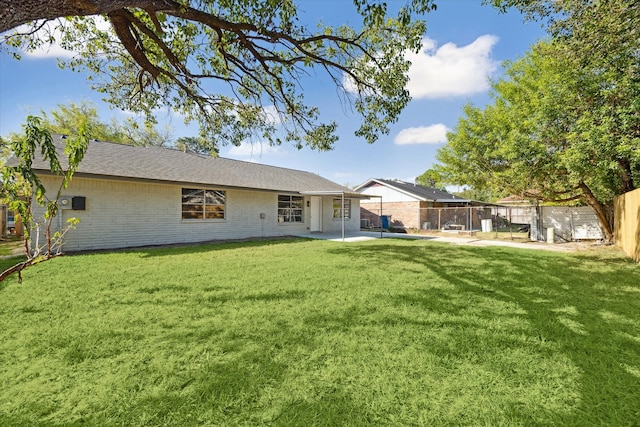 rear view of property with a yard and a patio