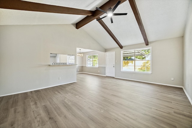 unfurnished living room with hardwood / wood-style floors, vaulted ceiling with beams, and ceiling fan with notable chandelier