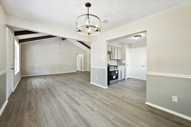 unfurnished living room featuring light hardwood / wood-style floors, lofted ceiling with beams, and a chandelier