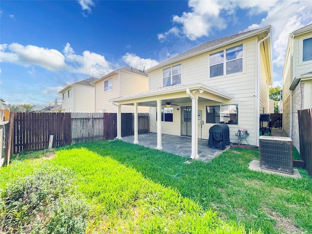 rear view of property with a patio area, cooling unit, a yard, and ceiling fan