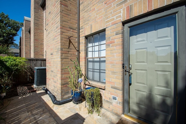 doorway to property featuring a patio area and cooling unit