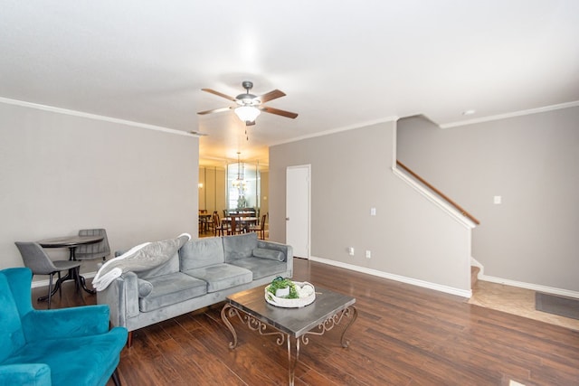 living room with ornamental molding, dark wood-type flooring, and ceiling fan