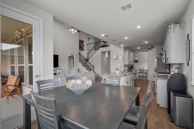 dining space with ceiling fan, hardwood / wood-style flooring, and sink