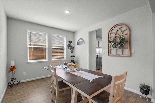 dining space with wood-type flooring