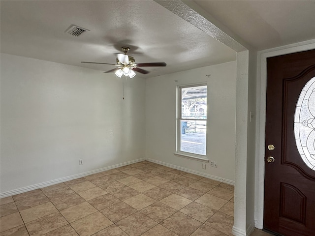 tiled foyer featuring ceiling fan and a textured ceiling