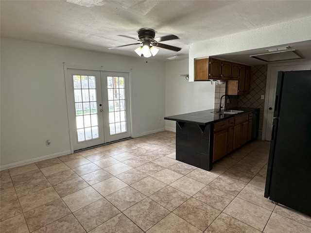 kitchen featuring ceiling fan, french doors, sink, black fridge, and kitchen peninsula