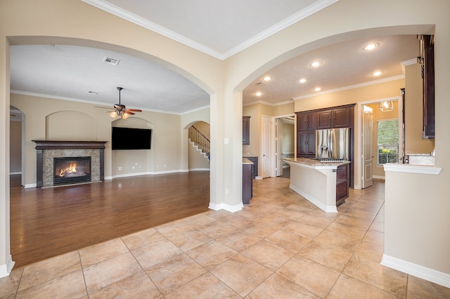 kitchen featuring a kitchen island, a breakfast bar area, light hardwood / wood-style flooring, crown molding, and stainless steel fridge with ice dispenser