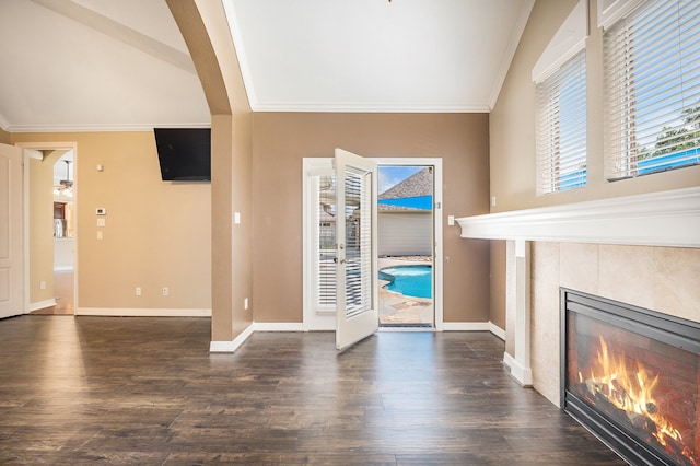 unfurnished living room with a tiled fireplace, plenty of natural light, and dark hardwood / wood-style flooring