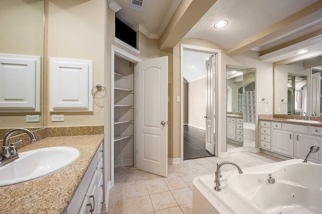 bathroom with vanity, a bathtub, and tile patterned flooring