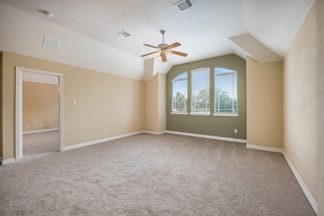 empty room featuring lofted ceiling, light colored carpet, and ceiling fan