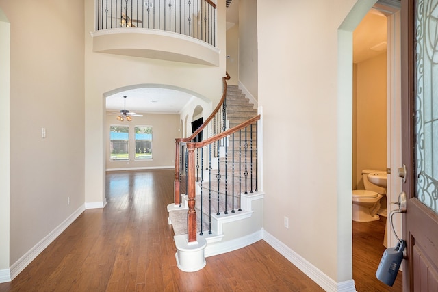 interior space featuring a high ceiling, wood-type flooring, and ceiling fan