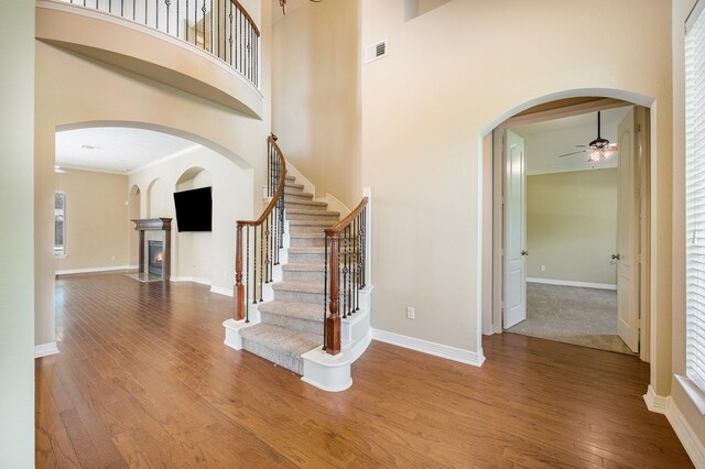 entryway featuring hardwood / wood-style flooring, ornamental molding, and a high ceiling