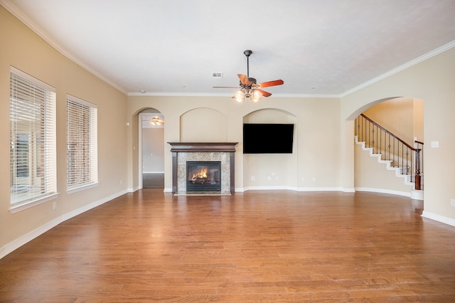 unfurnished living room with ornamental molding, a high end fireplace, and light hardwood / wood-style floors