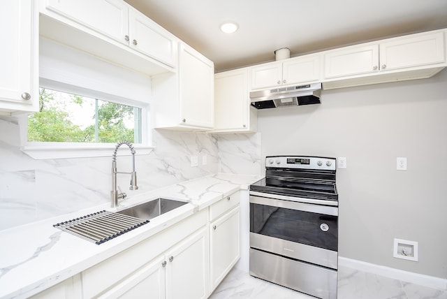 kitchen featuring light stone countertops, backsplash, stainless steel electric stove, sink, and white cabinetry