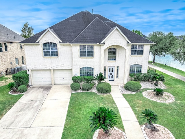 french provincial home featuring a front lawn and a garage