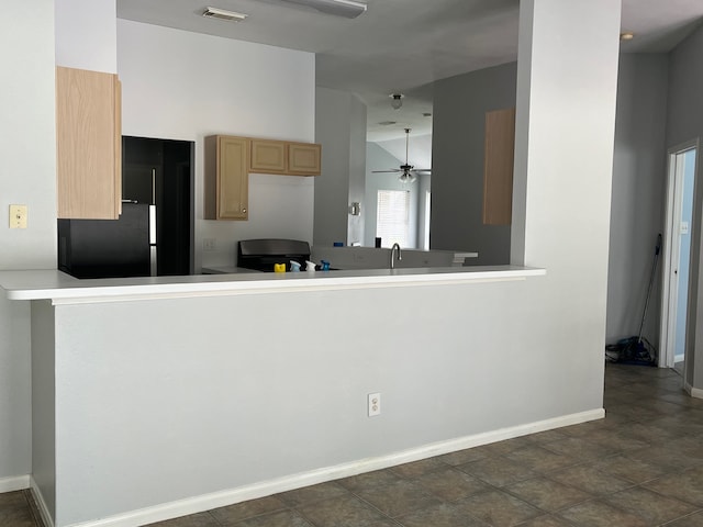 kitchen featuring lofted ceiling, black fridge, ceiling fan, light brown cabinetry, and kitchen peninsula