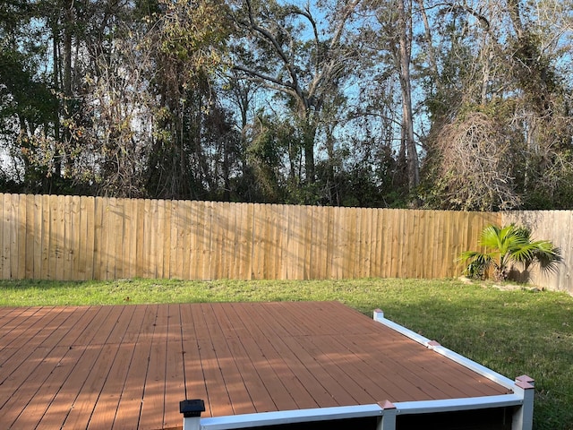 wooden deck featuring a lawn