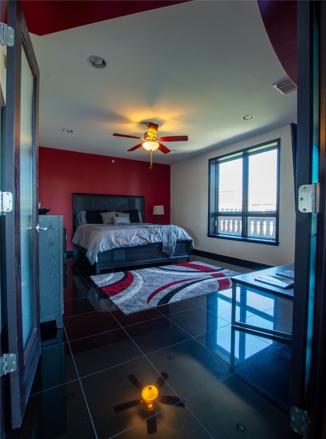 bedroom with dark tile patterned floors and ceiling fan