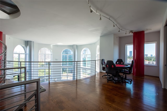 office space featuring rail lighting, dark wood-type flooring, and a wealth of natural light