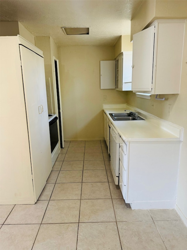 kitchen with white cabinetry, light tile patterned floors, sink, and white appliances