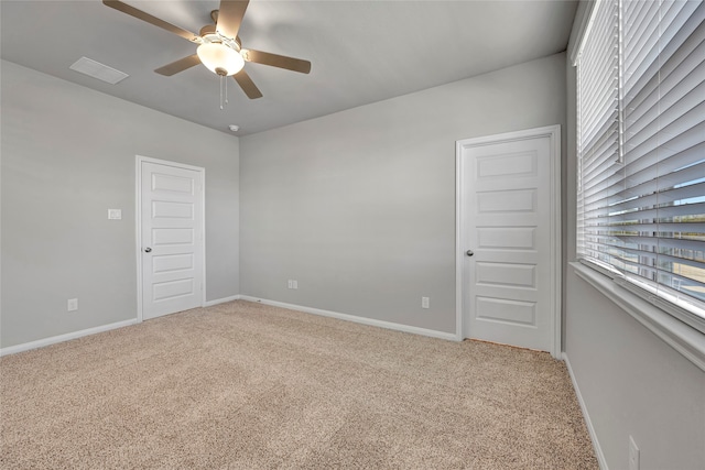 carpeted spare room featuring ceiling fan