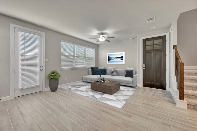 living room with light hardwood / wood-style floors and ceiling fan