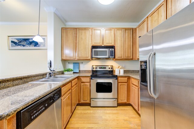 kitchen featuring light hardwood / wood-style flooring, hanging light fixtures, ornamental molding, sink, and appliances with stainless steel finishes