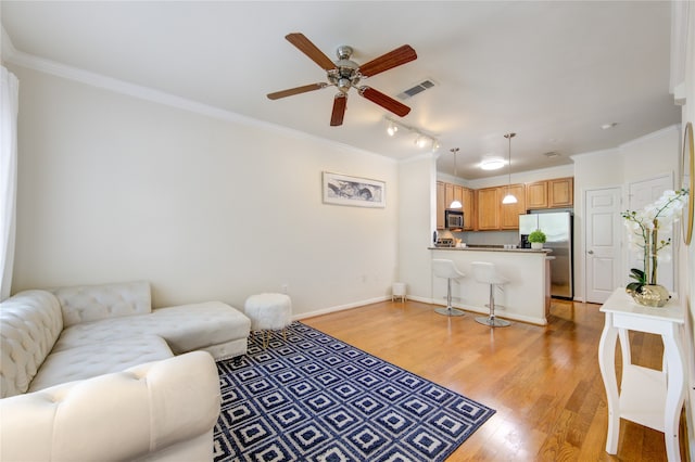 living room with ornamental molding, track lighting, light hardwood / wood-style flooring, and ceiling fan