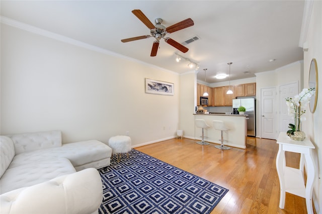 living room with crown molding, light wood-type flooring, and ceiling fan