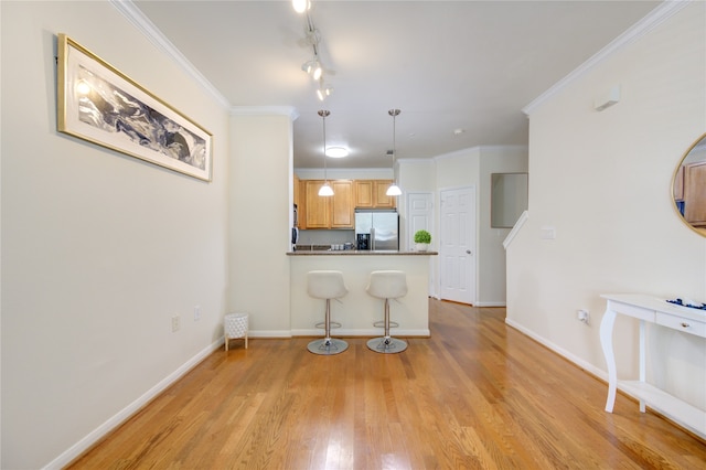 kitchen featuring stainless steel fridge with ice dispenser, pendant lighting, ornamental molding, light hardwood / wood-style flooring, and light brown cabinets