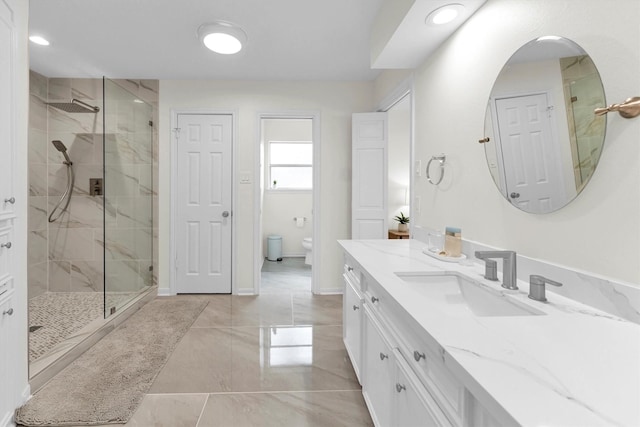bathroom featuring vanity, baseboards, a shower stall, and toilet