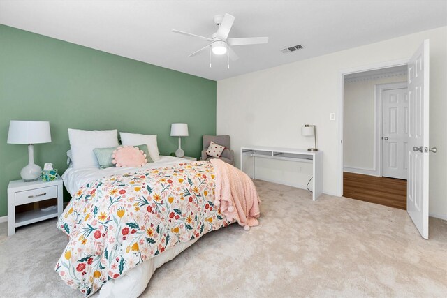 carpeted bedroom featuring ceiling fan, visible vents, and baseboards
