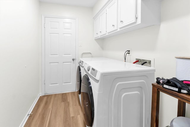 clothes washing area with baseboards, cabinet space, light wood finished floors, and washer and dryer