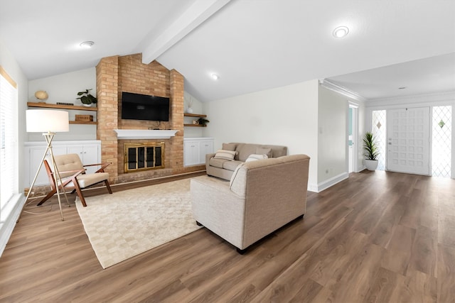 living room featuring hardwood / wood-style flooring, lofted ceiling with beams, and a brick fireplace