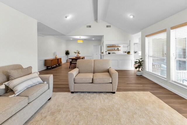 living area with wood finished floors, beamed ceiling, baseboards, high vaulted ceiling, and recessed lighting