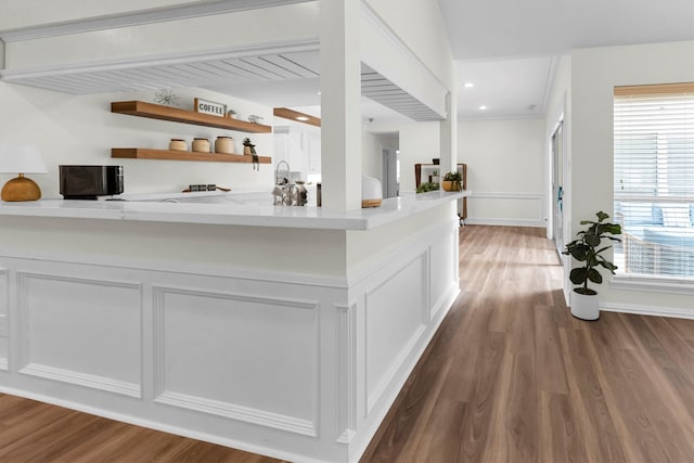 kitchen with kitchen peninsula, white cabinetry, and dark wood-type flooring