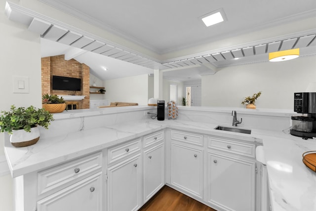 kitchen featuring vaulted ceiling with beams, kitchen peninsula, white cabinetry, light stone counters, and dark hardwood / wood-style floors