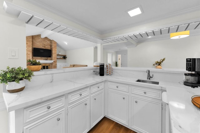 kitchen featuring white cabinets, light stone countertops, a sink, dark wood finished floors, and lofted ceiling