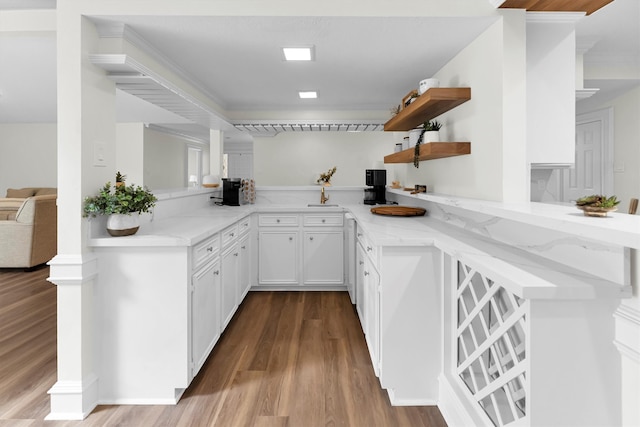 kitchen featuring light hardwood / wood-style flooring, kitchen peninsula, and white cabinets