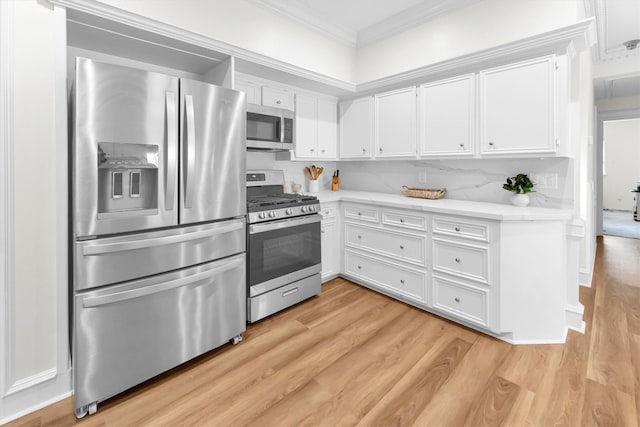 kitchen with crown molding, light wood-type flooring, light countertops, white cabinets, and appliances with stainless steel finishes