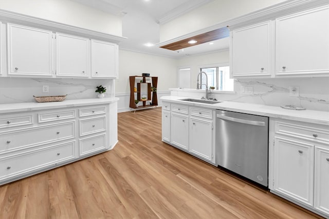 kitchen with a sink, crown molding, stainless steel dishwasher, and white cabinets