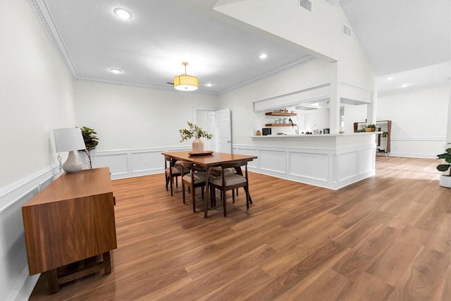 dining space with crown molding, recessed lighting, visible vents, and light wood-style flooring