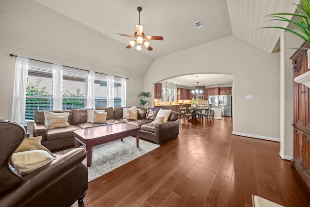 living room featuring dark hardwood / wood-style floors, a healthy amount of sunlight, high vaulted ceiling, and ceiling fan with notable chandelier